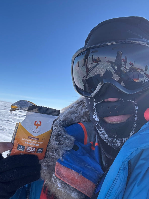 An expedition member in goggles holding a Phoenix Bar