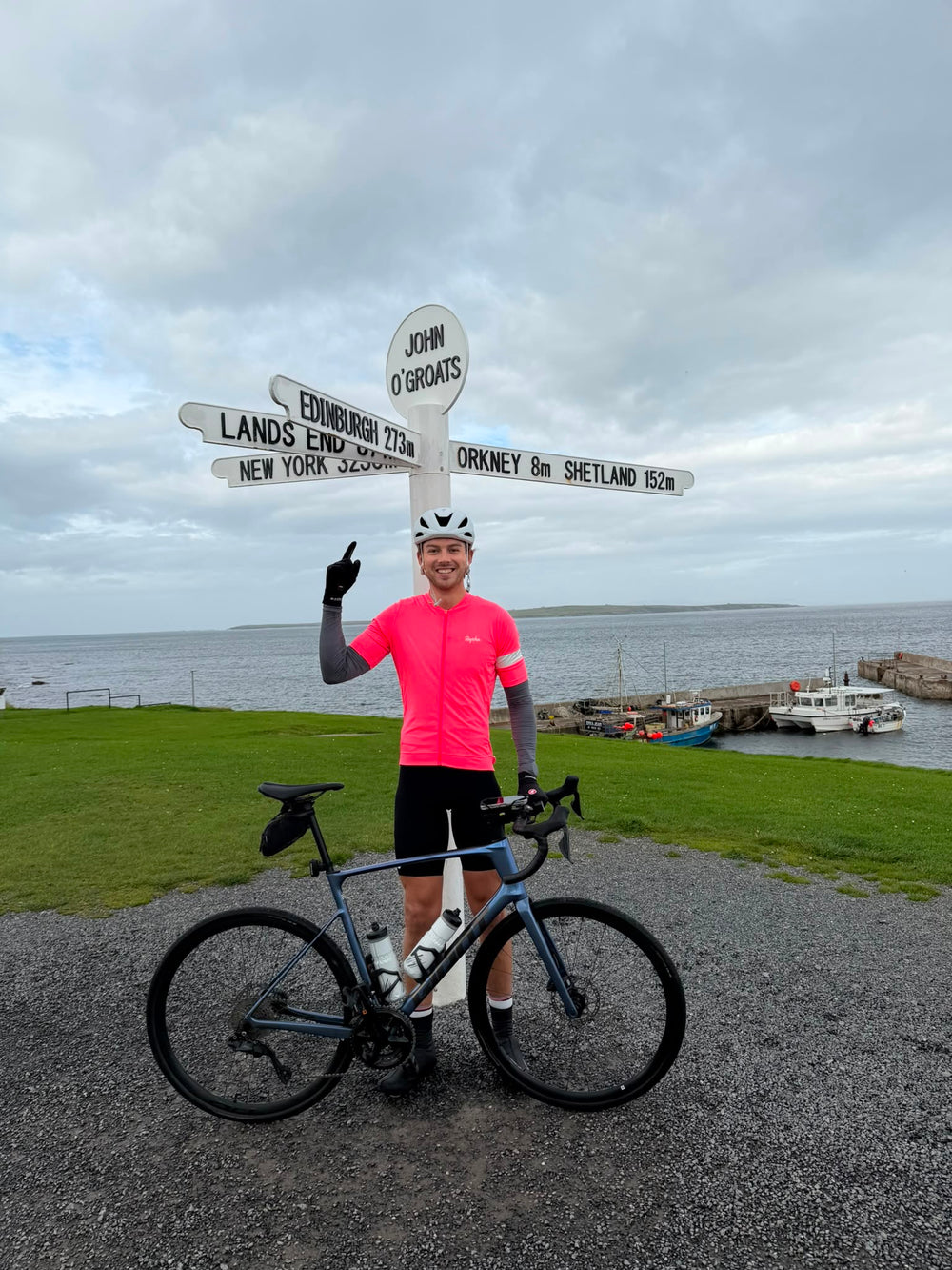 A cyclist with his bike at John o' Groats