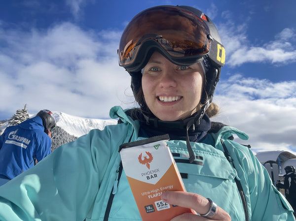 A skier smiling on the slopes with a Phoenix Bar